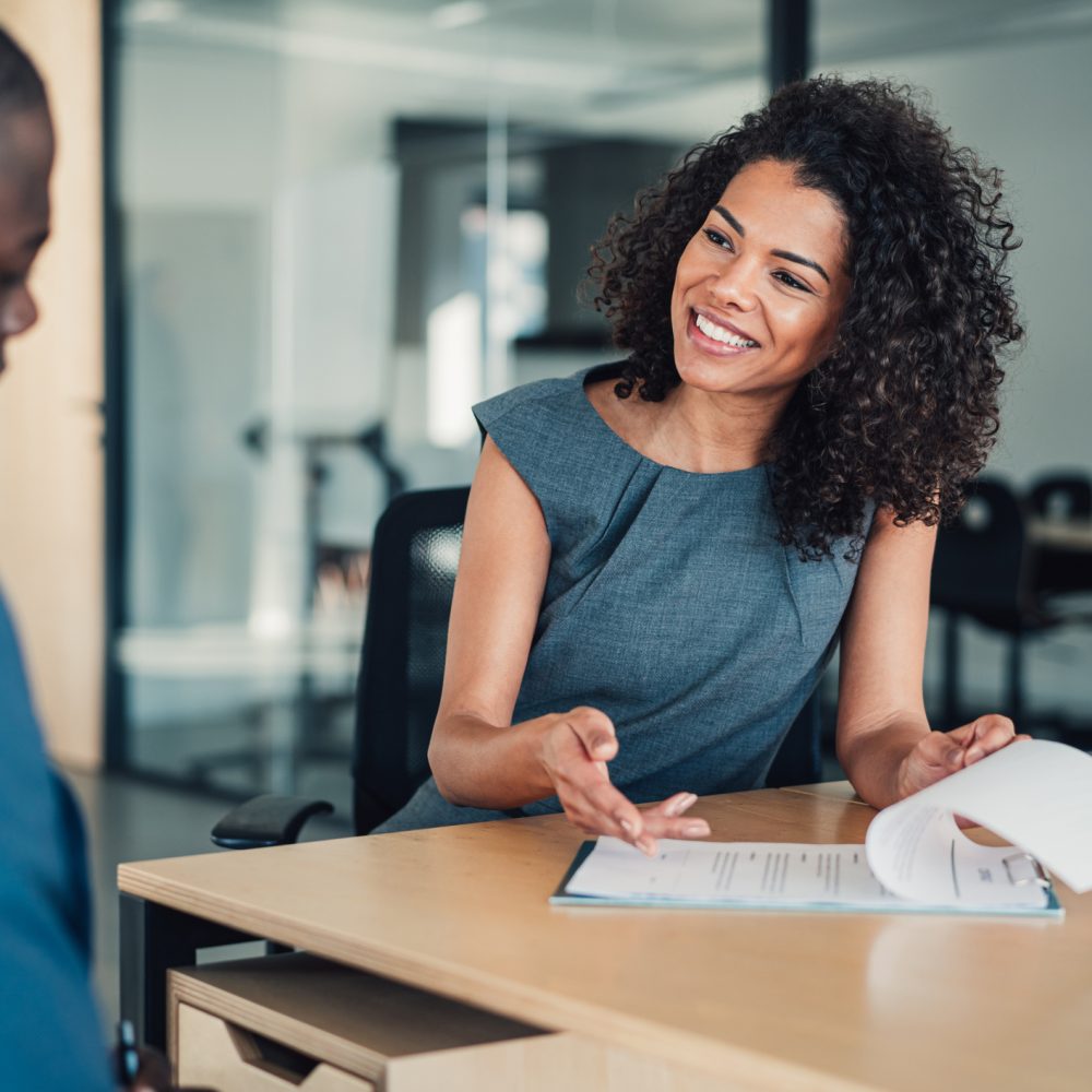 Shot of two business persons filling in paperwork in the office. Businessman and businesswoman signing a document in board room.